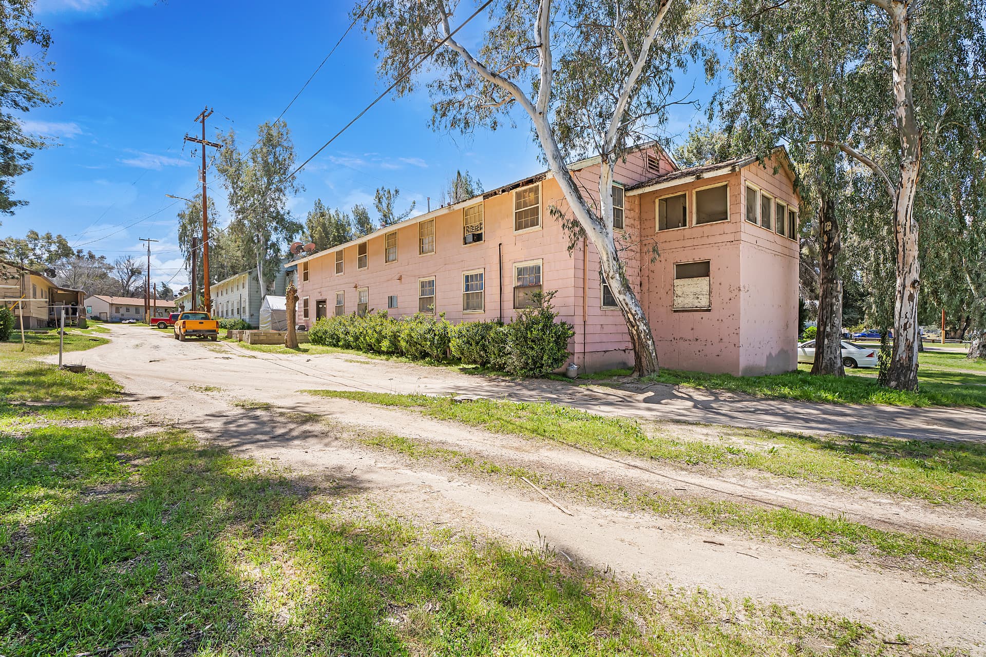 Pink two-story barracks building on a quiet dirt street