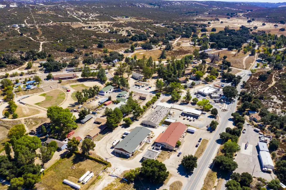 Aerial view of the Village of Campo buildings and rural roads surrounded by green hills