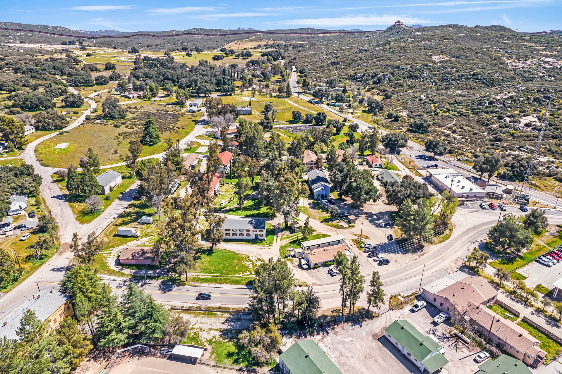 Aerial view of The Village of Campo nestled among green desert hills and winding backcountry roads