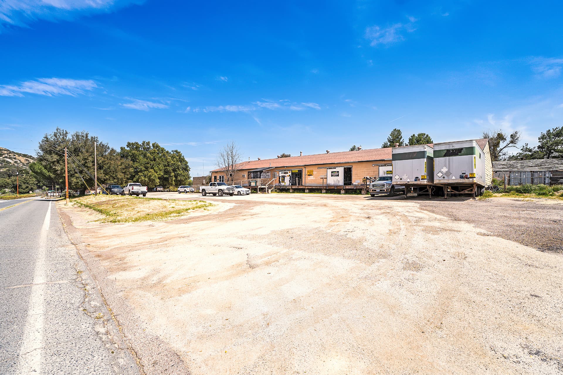 Commercial building fronting the highway with parked trucks and trailers